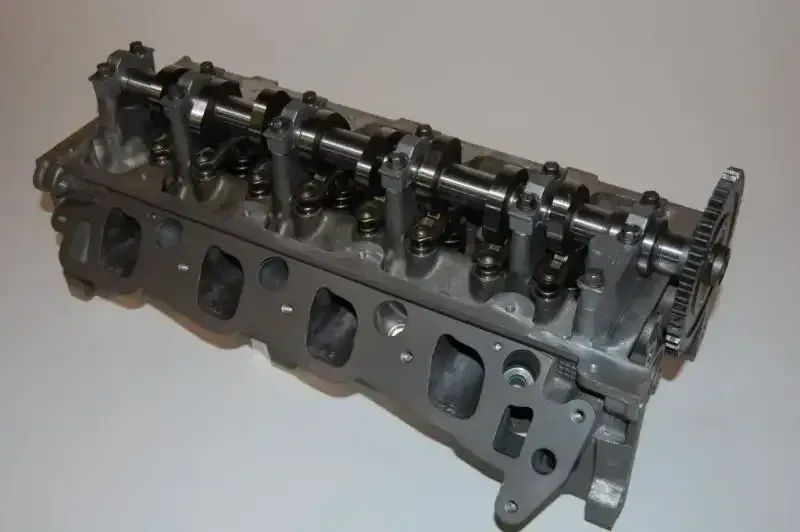 A close up of a cylinder head on a white surface