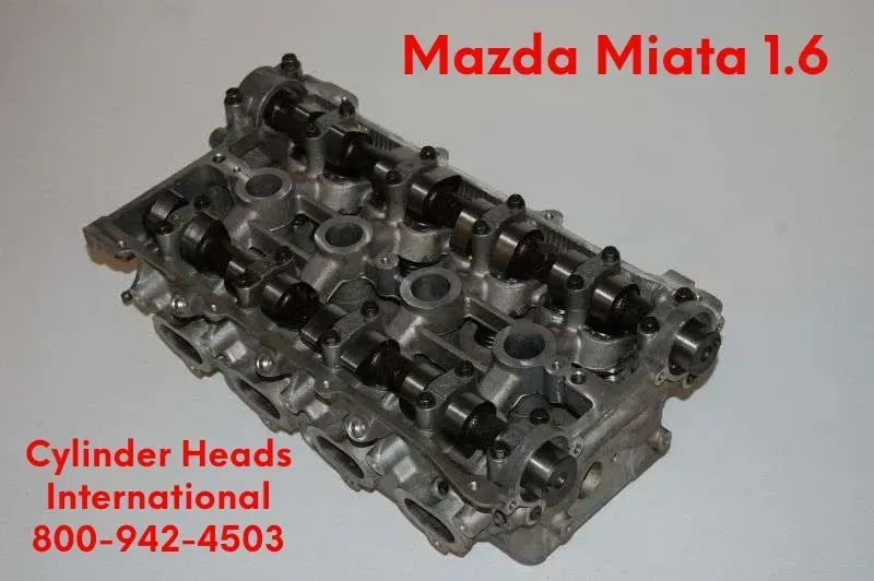 Mazda Miata 1.6 cylinder head on white background with Cylinder Heads International contact text