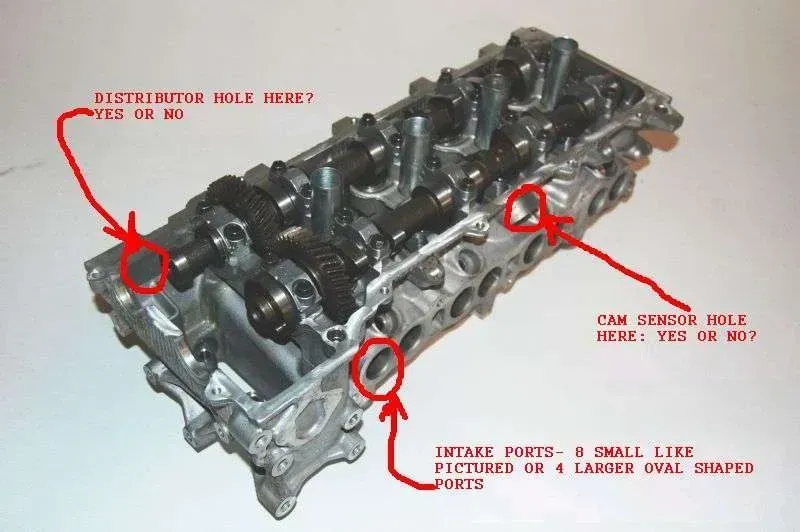 A close up of a cylinder head with a red arrow pointing to the distributor hole