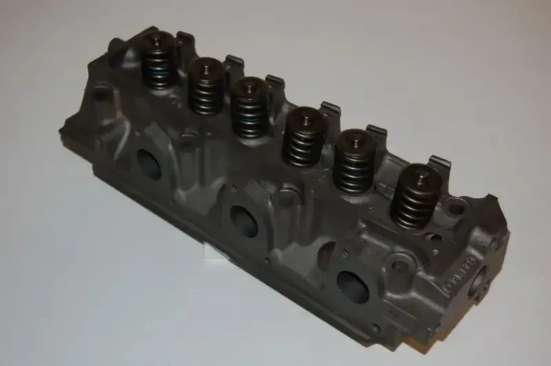 A close up of a cylinder head on a white surface
