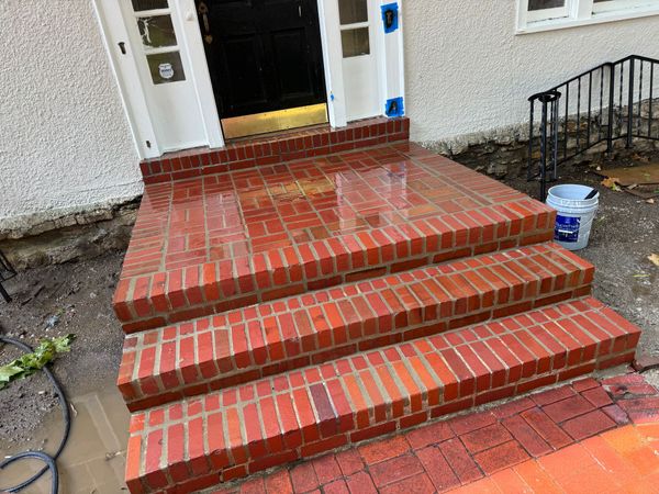 A set of red brick steps leading up to a house.