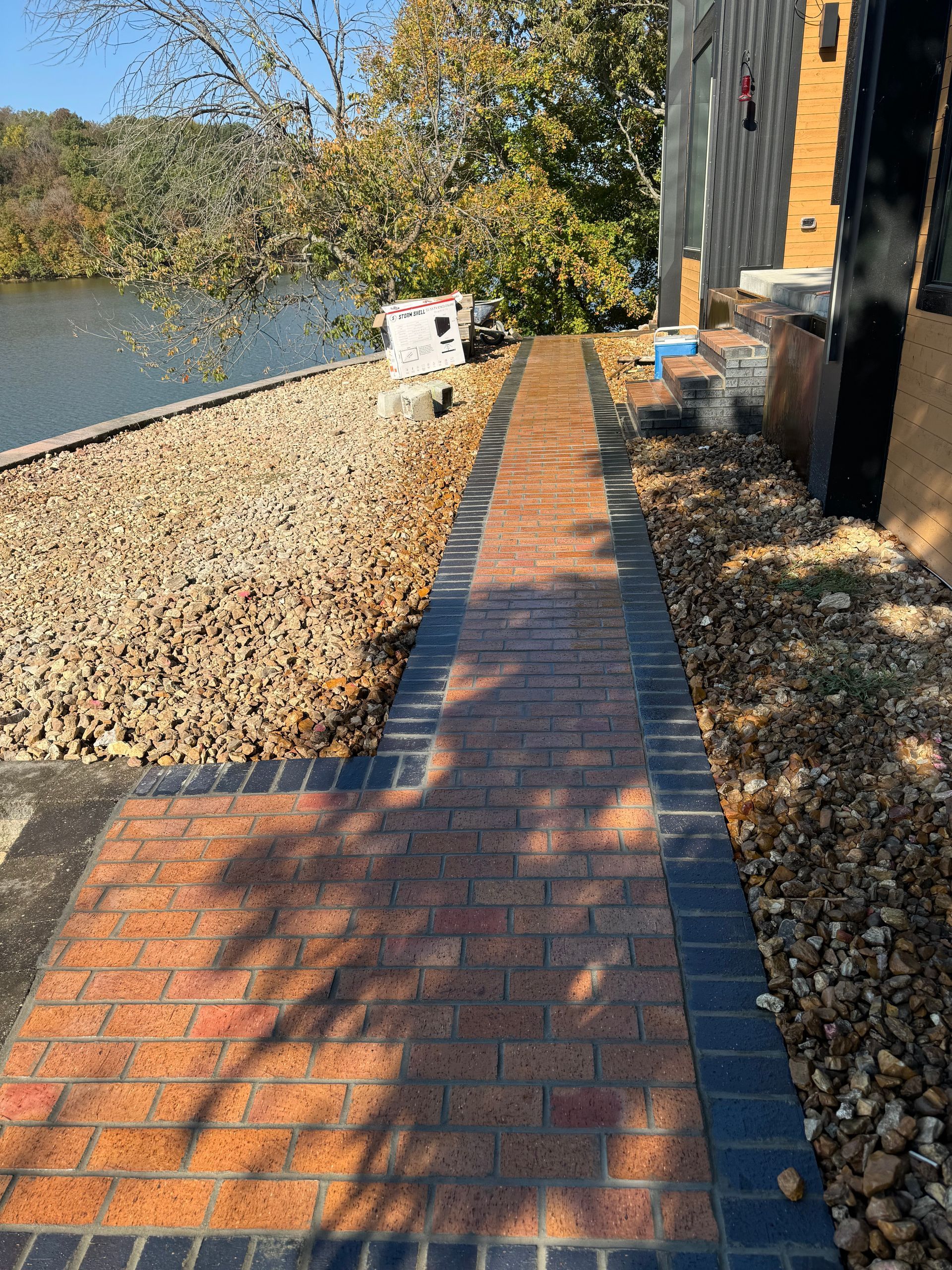 A brick walkway leading to a body of water.