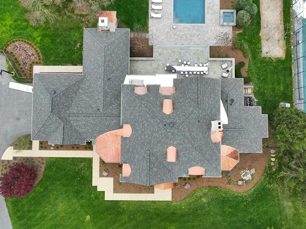 Asphalt shingles and copper dormer roof installation on a residential estate in Maryland.