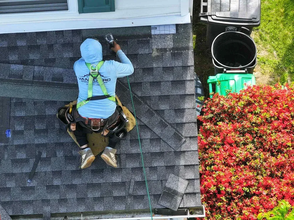 Vanguard roofing professional installing asphalt shingles on a residential home in Maryland