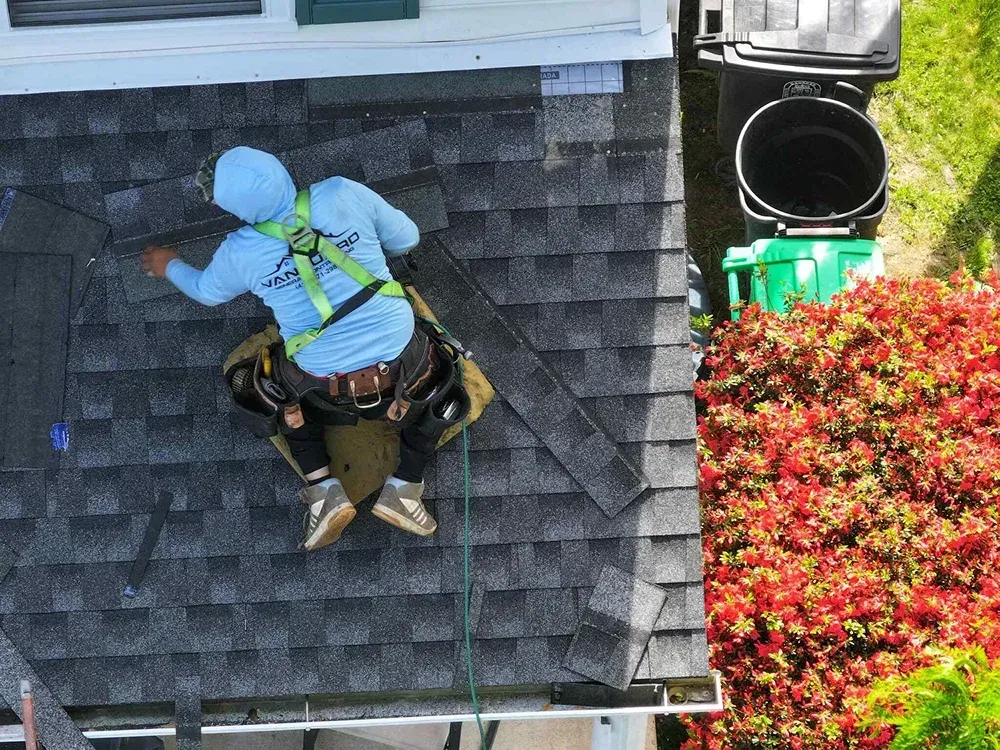 Vanguard Roofing technician installing shingles on a residential home in Maryland