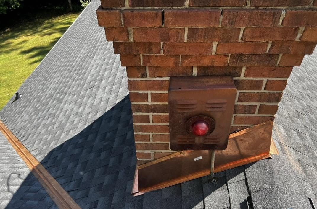 Residential roof and chimney area representing flashing repair work by Vanguard General Contracting