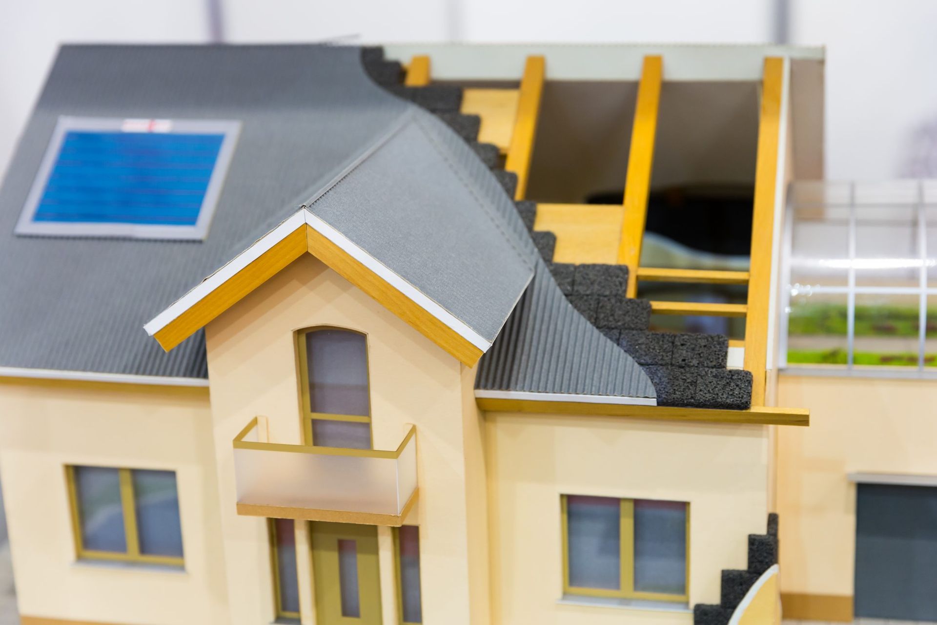 Educational model showing the layers of a residential roof installation and insulation for Maryland homeowners.