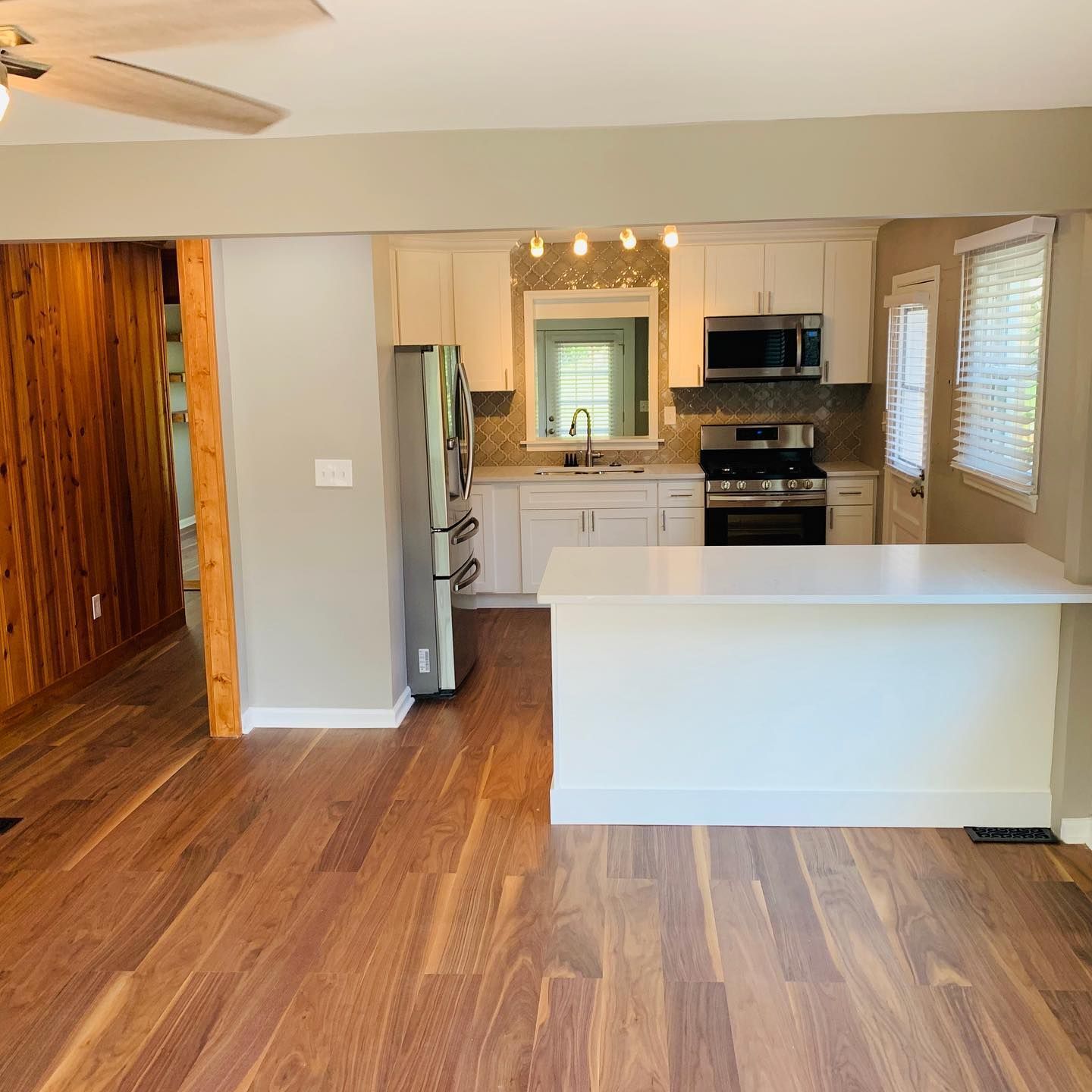 A kitchen with hardwood floors and stainless steel appliances