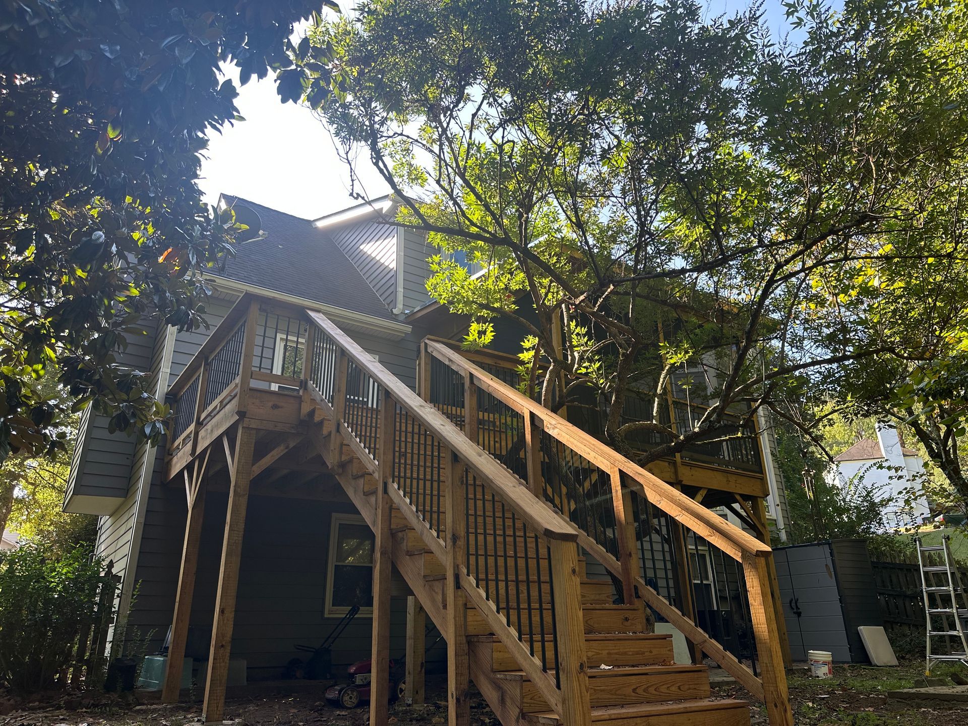 A house with a wooden deck and stairs leading up to it.