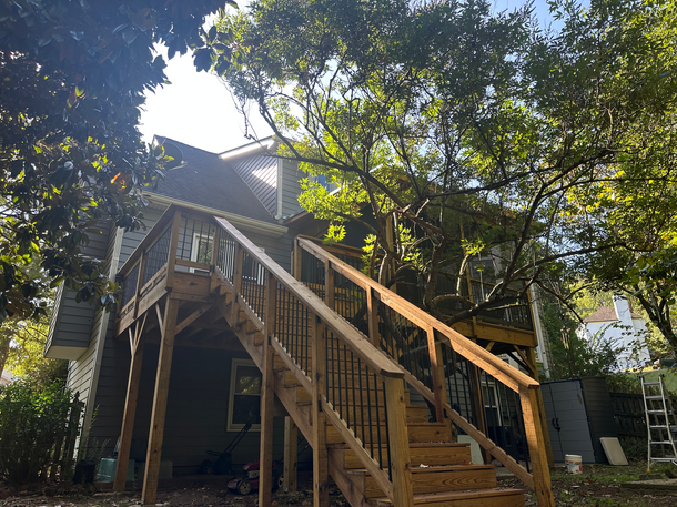A house with a wooden deck and stairs leading up to it.