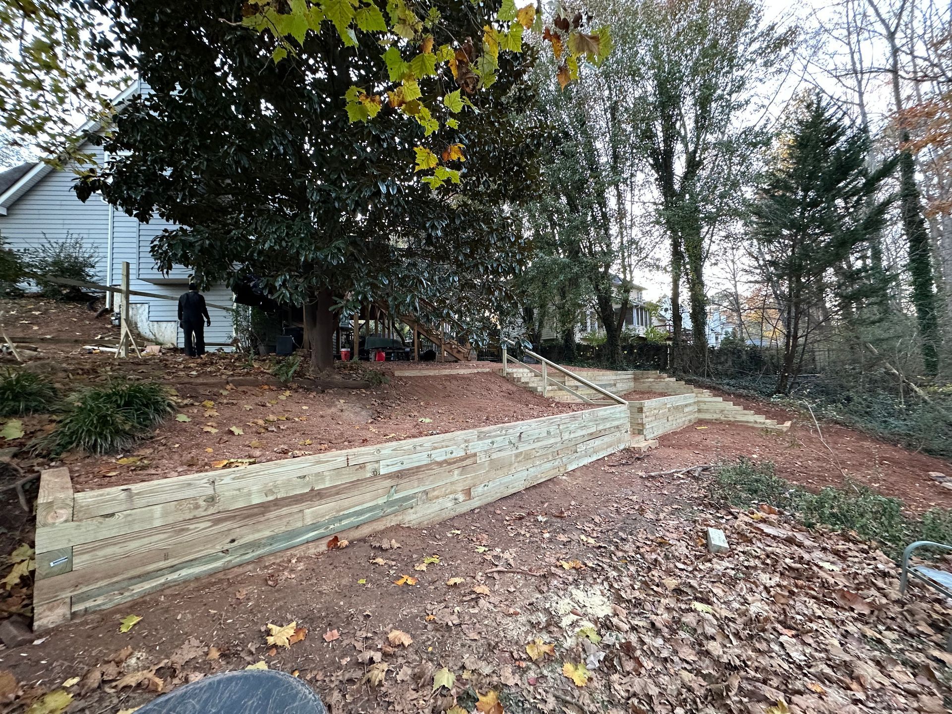 A wooden fence is being built in the backyard of a house.