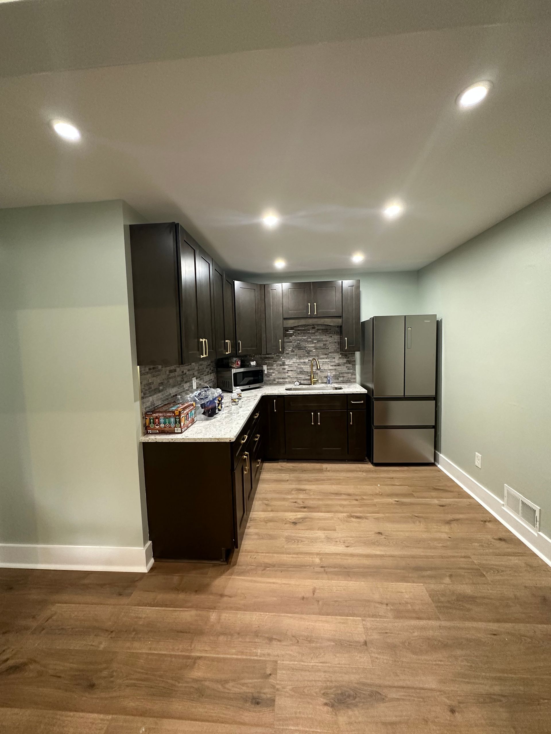 A kitchen with stainless steel appliances and wooden floors.