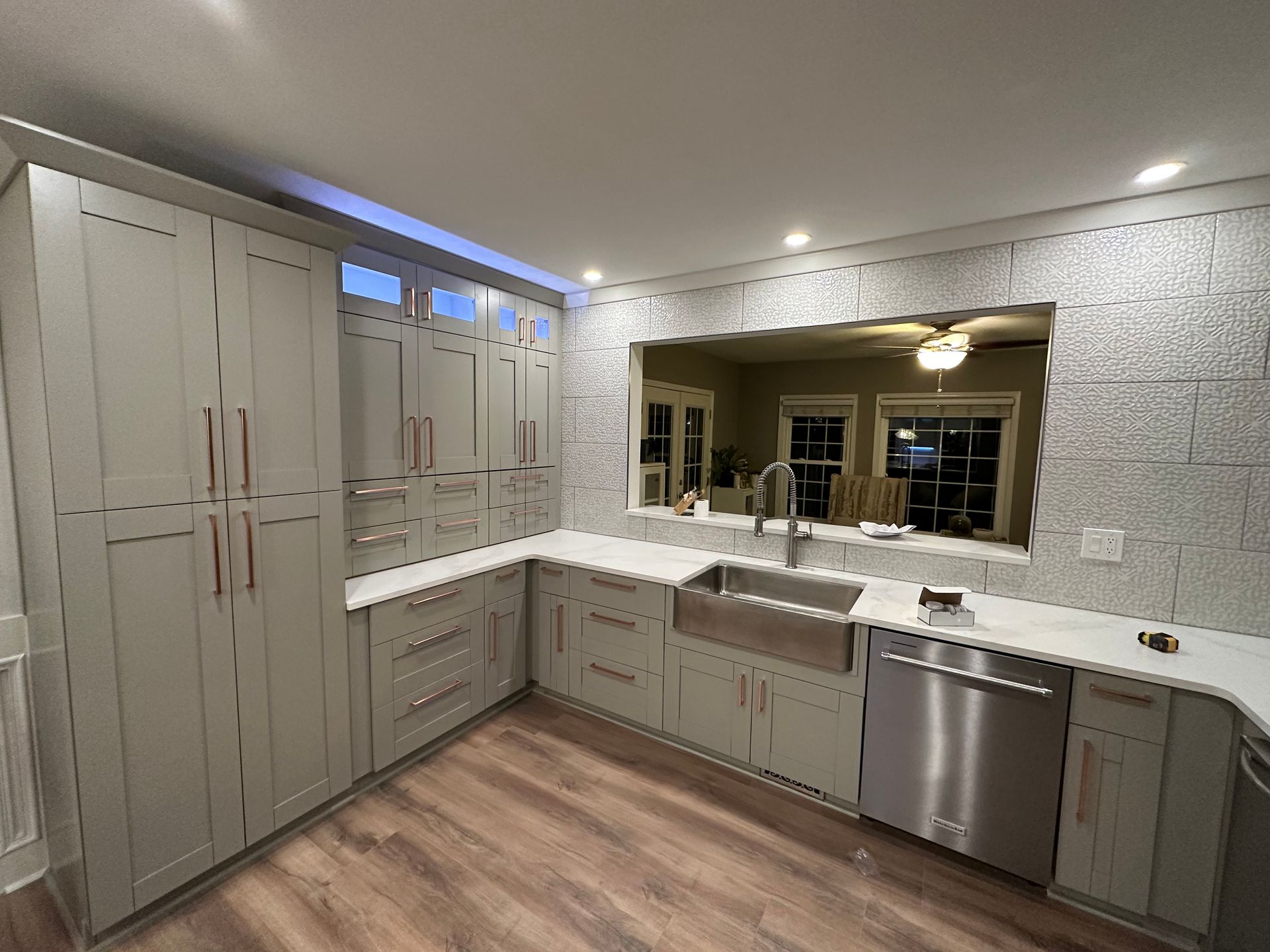 A kitchen with white cabinets , stainless steel appliances , and a large sink.