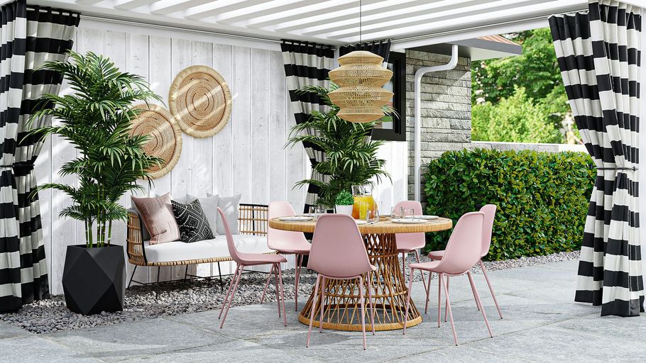 Stylish outdoor patio with pink chairs, round table, white sofa, greenery, and black-and-white drapes