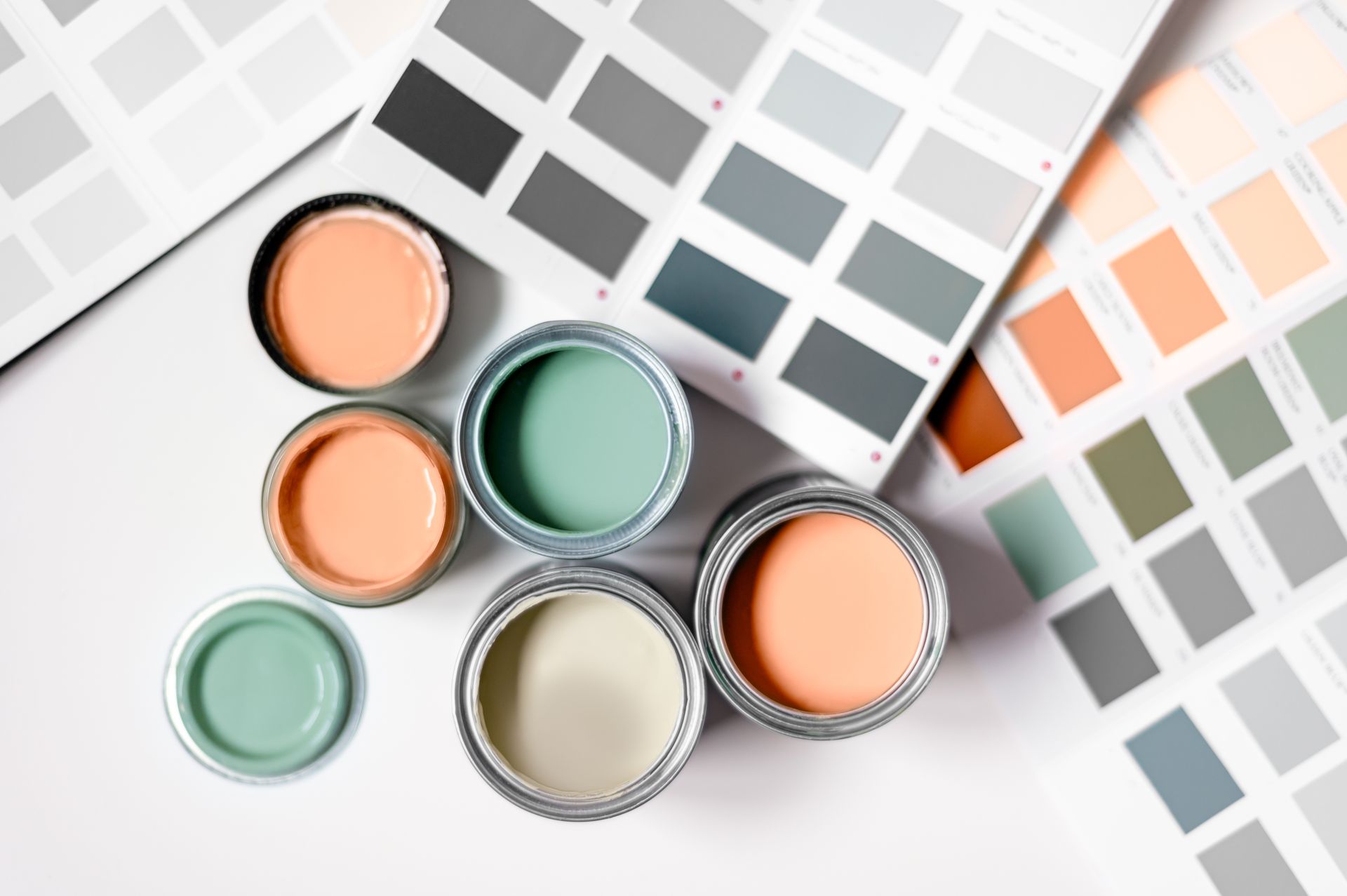 A bunch of paint cans sitting on top of a table next to a color palette.