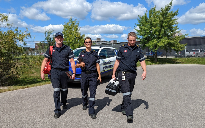 A group of paramedics are walking down a street.