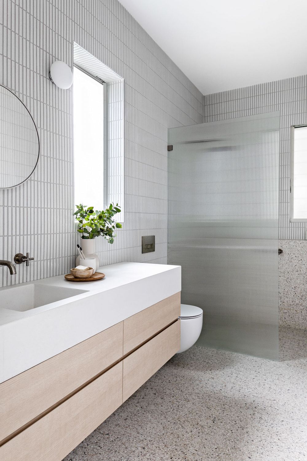 White kitchen with island, marble countertops, and brass light fixtures. — Goode By Design in Unanderra, NSW