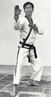 A black and white photo of a man in a karate uniform.