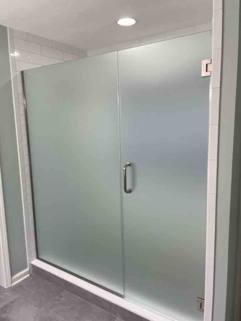 Frosted glass shower door in a modern bathroom.