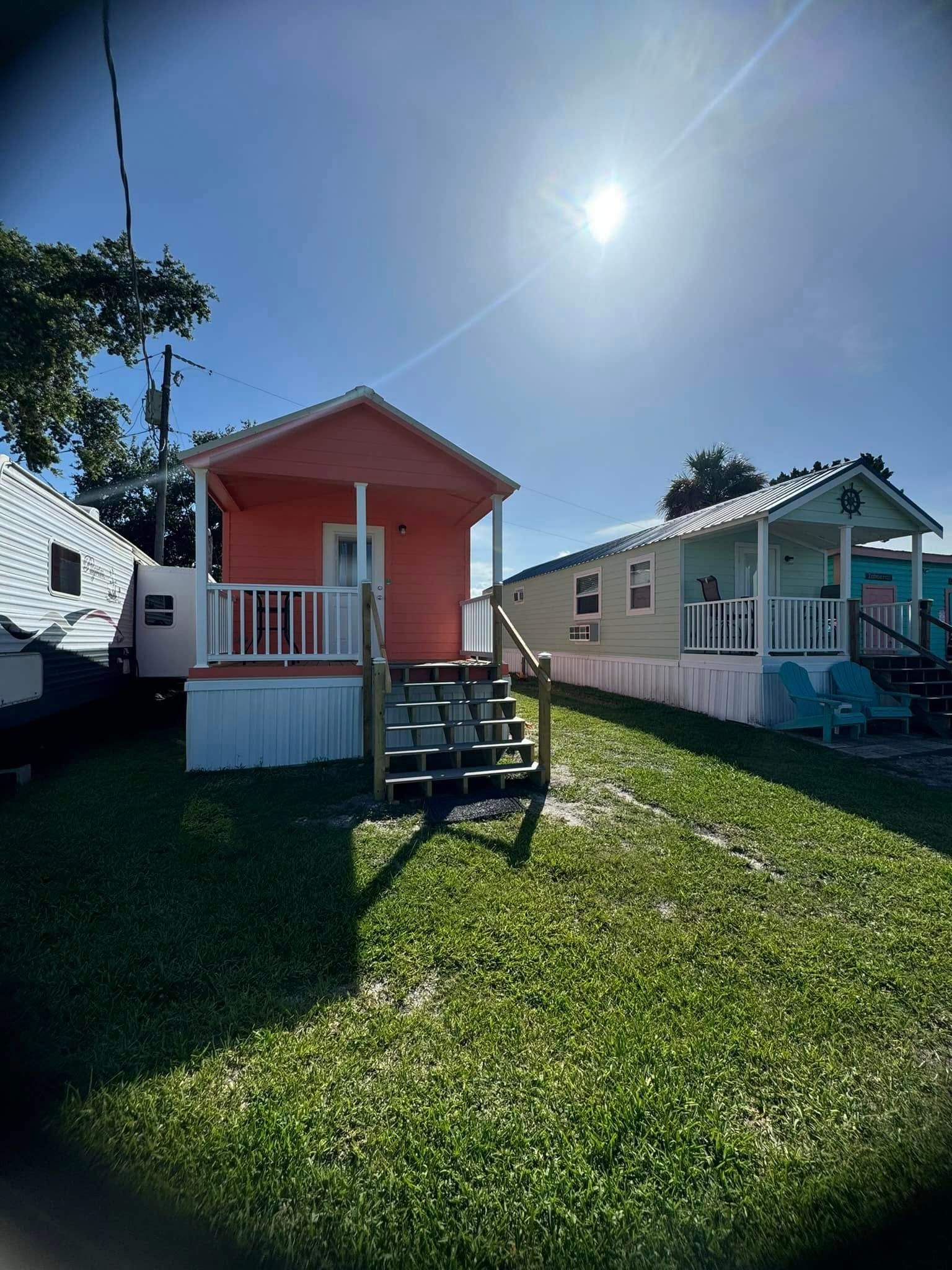Two quaint houses under a shining sun, set against a clear sky, evoking a cheerful and sunny day.
