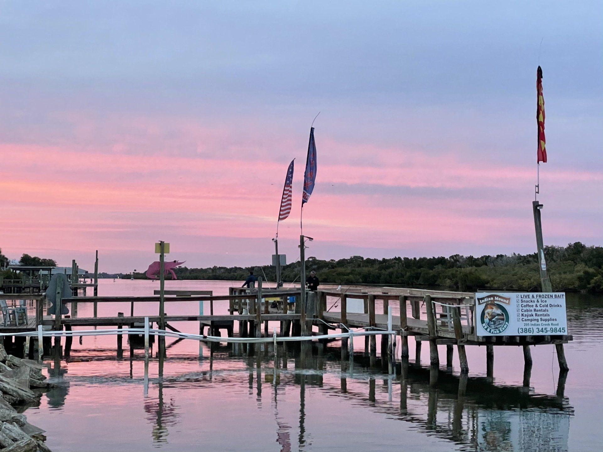 A dock overlooking a body of water with a sunset in the background