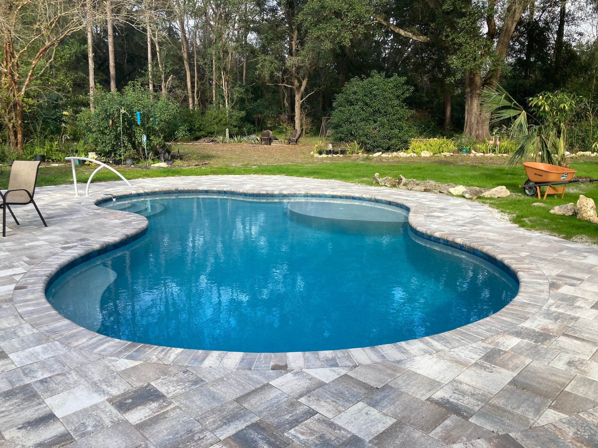 Custom freeform pool with concrete paver deck