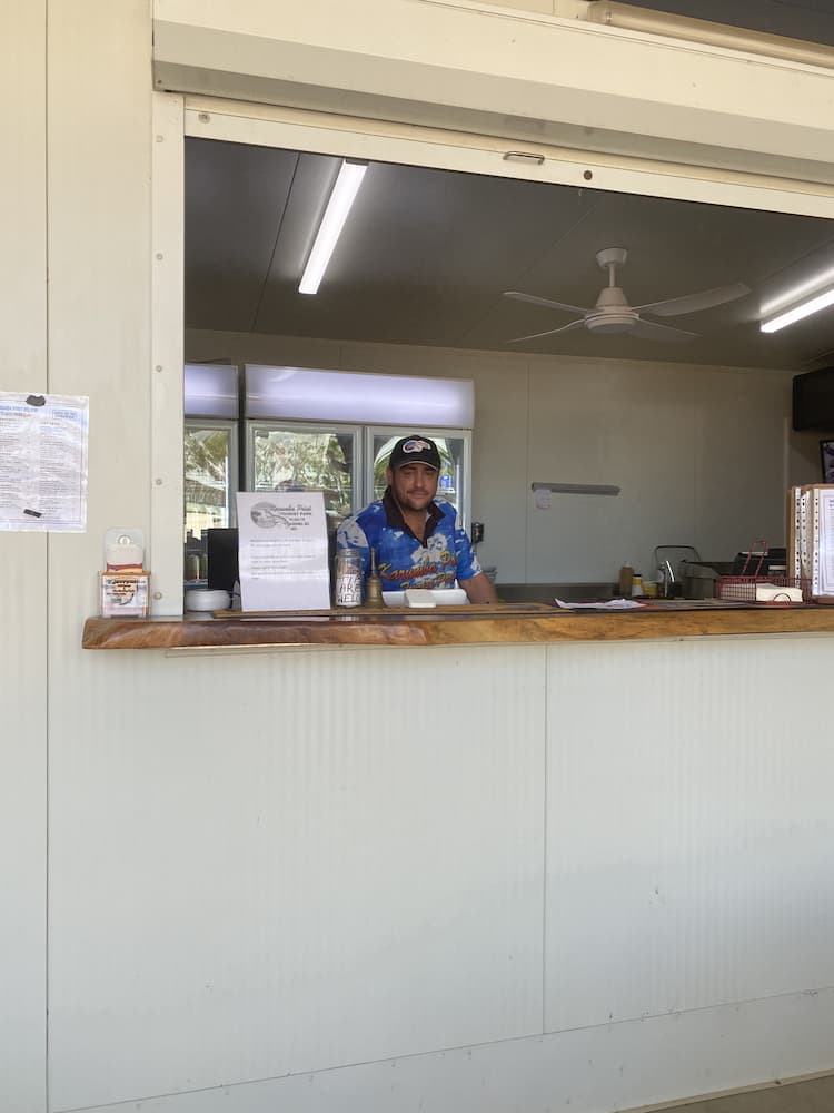 A Person Stands Behind a Counter at a Window — Karumba Point Holiday Tourist Park in Karumba, QLD