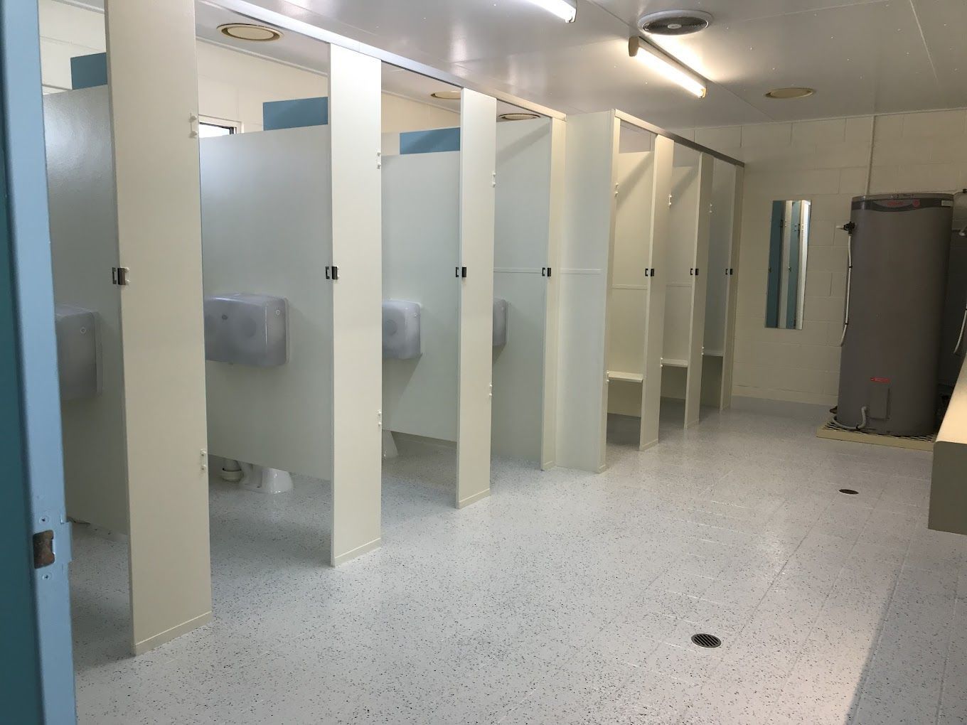Empty Public Restroom With Multiple Stalls and Speckled Floor — Karumba Point Holiday Tourist Park in Karumba, QLD
