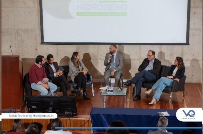 Un grupo de personas están sentadas alrededor de una mesa frente a una pantalla que dice hidrógeno.