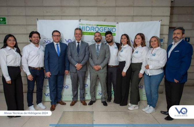 Un grupo de personas de pie frente a un cartel que dice hidrógeno.