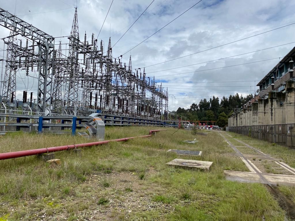 Una gran central eléctrica con muchas líneas eléctricas que la atraviesan.