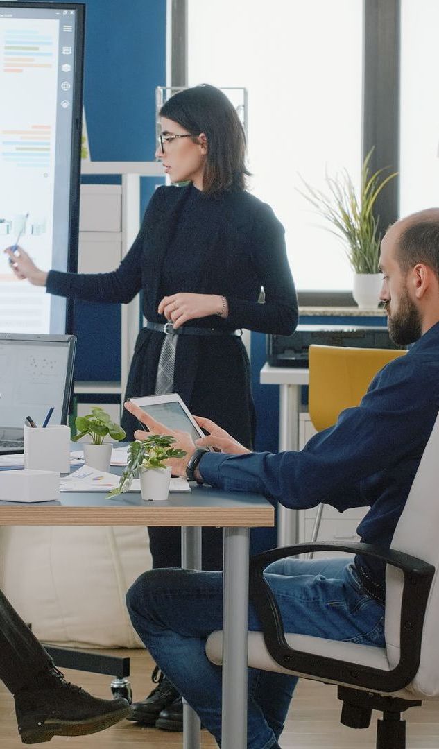 Una mujer está dando una presentación a un grupo de personas en una oficina.