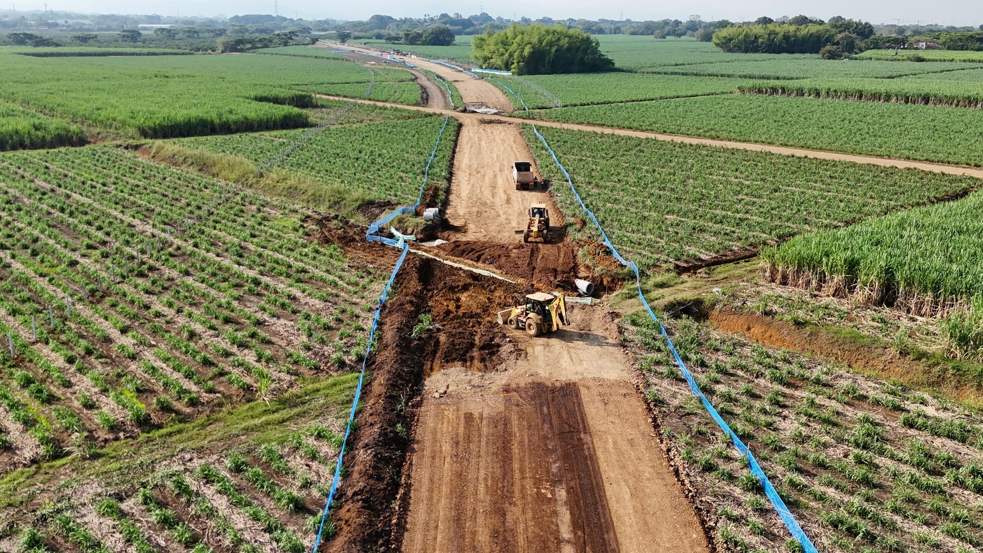 Una vista aérea de una carretera en construcción a través de un exuberante campo verde.