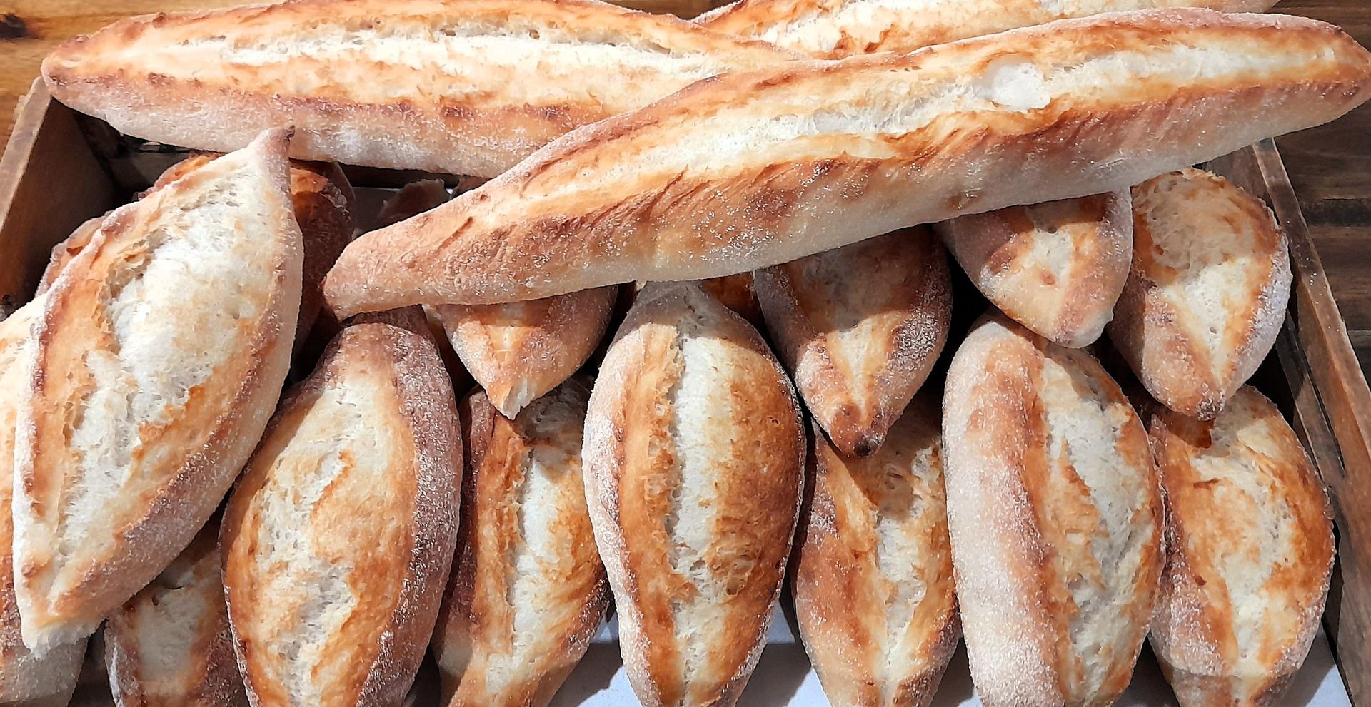 A bunch of bread is sitting in a box on a table