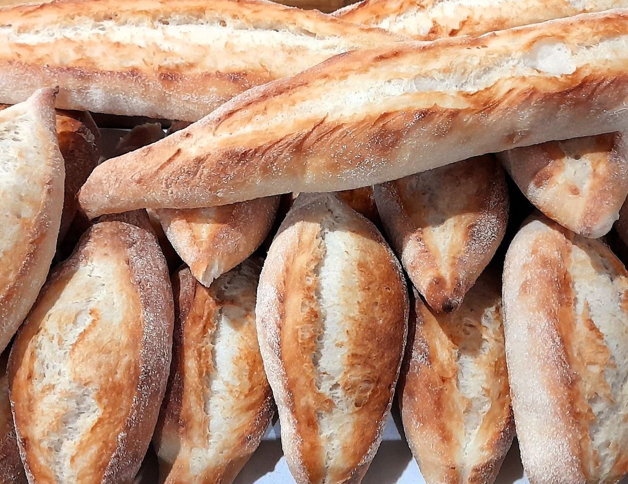 A bunch of loaves of bread are stacked on top of each other