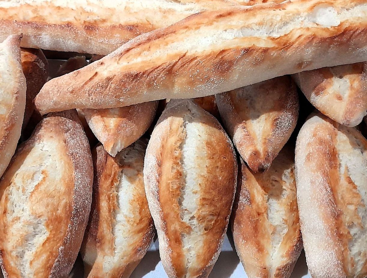A bunch of loaves of bread are stacked on top of each other