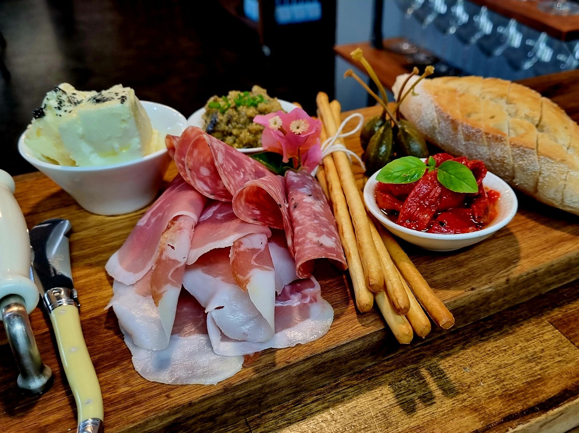 A wooden cutting board topped with meat and bread.
