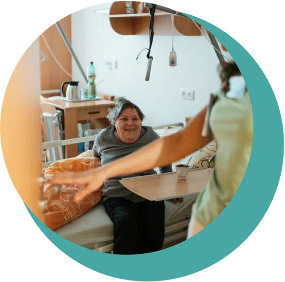 A woman is sitting in a hospital bed talking to another woman