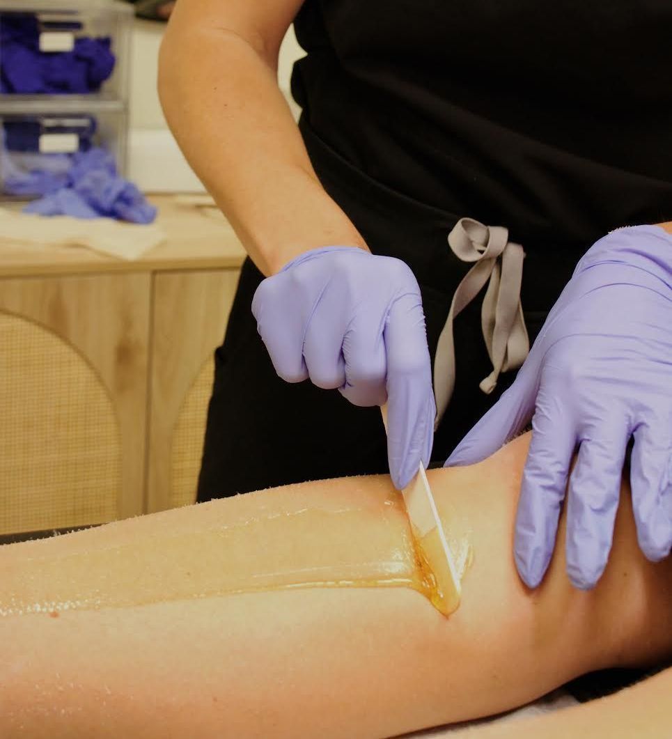 A woman is getting her legs waxed in a beauty salon. A woman is getting her legs waxed in a beauty salon.