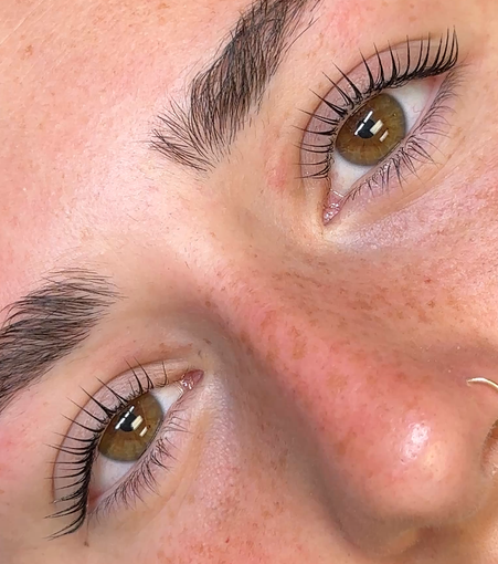 A woman is getting her eyelashes done at a beauty salon.
