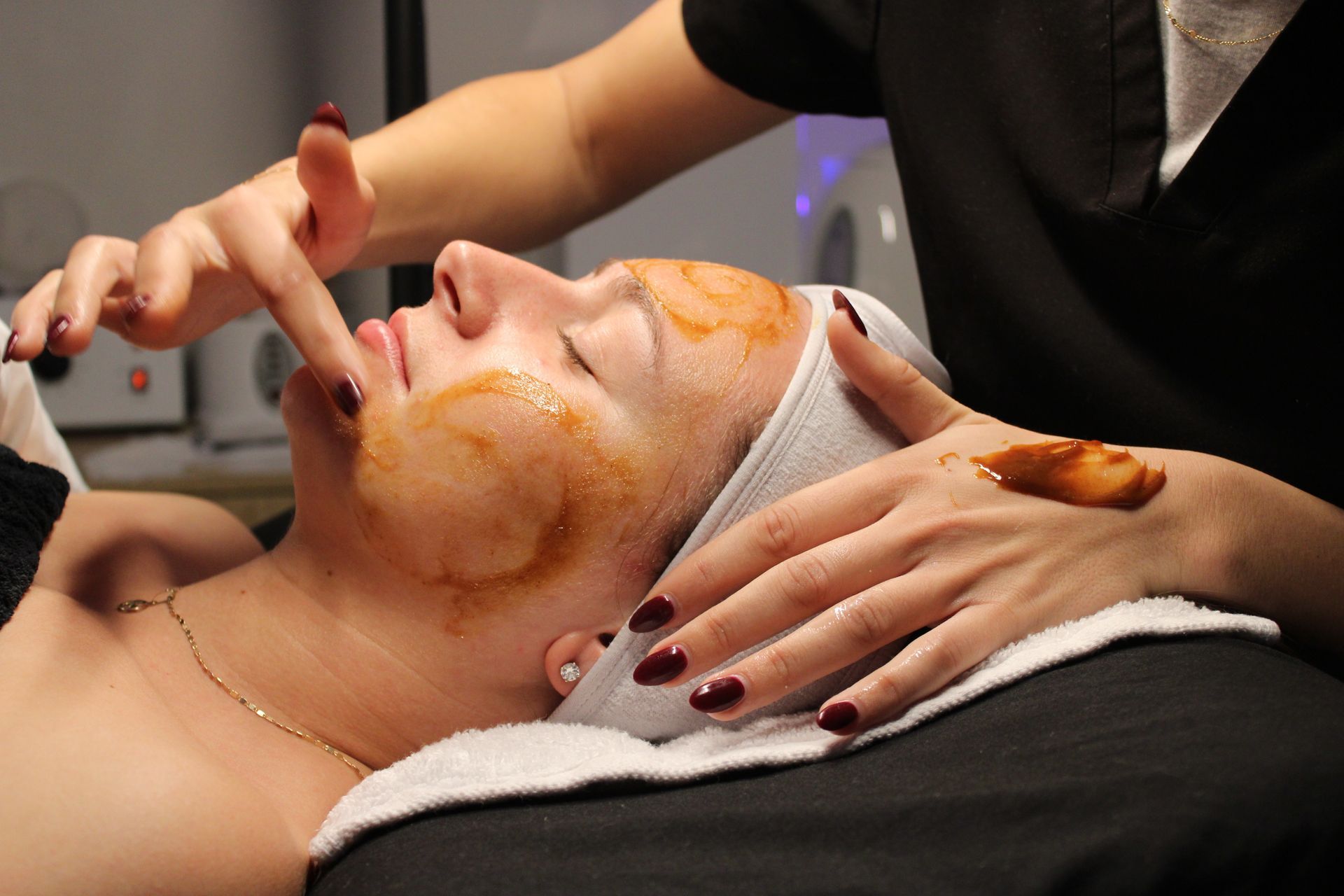 A woman is getting her eyelashes done with a mascara brush.