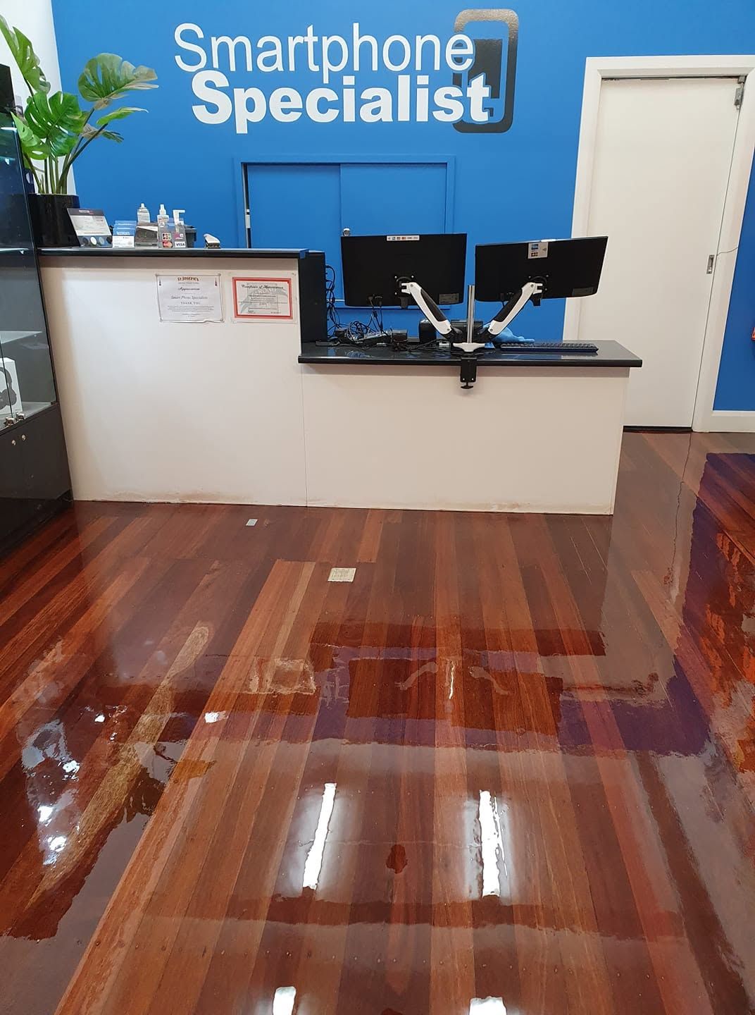 Smartphone repair shop interior with blue counter and glossy wooden floor