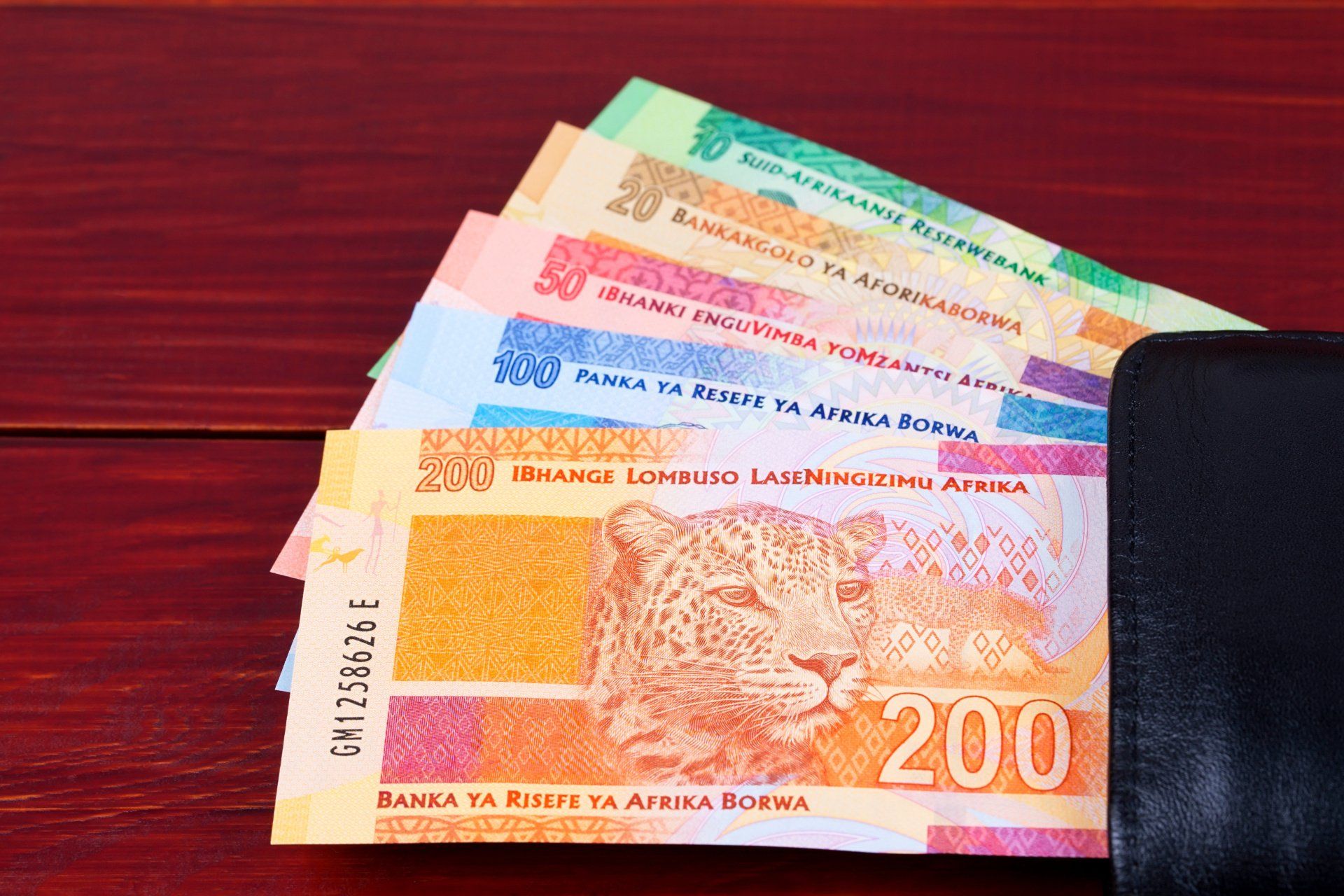 Why is cash still king? by Lipa Payments. Money (rands) displayed on a tabled.