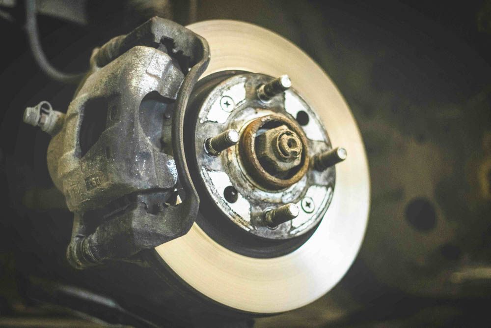A close up of a automobile brake assembly with rotors and brake pads and calipers