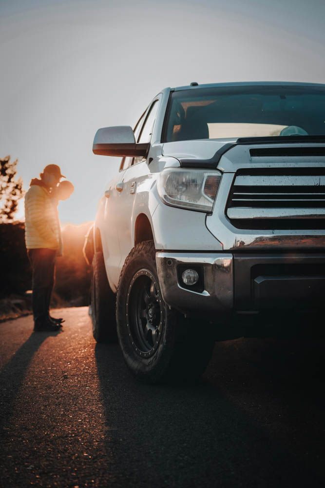 a mechanic and a customer are looking at a used truck to purchase from a used car dealer in newmarket ontario