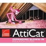 A pink panther is sitting on top of a pile of blown in insulation.