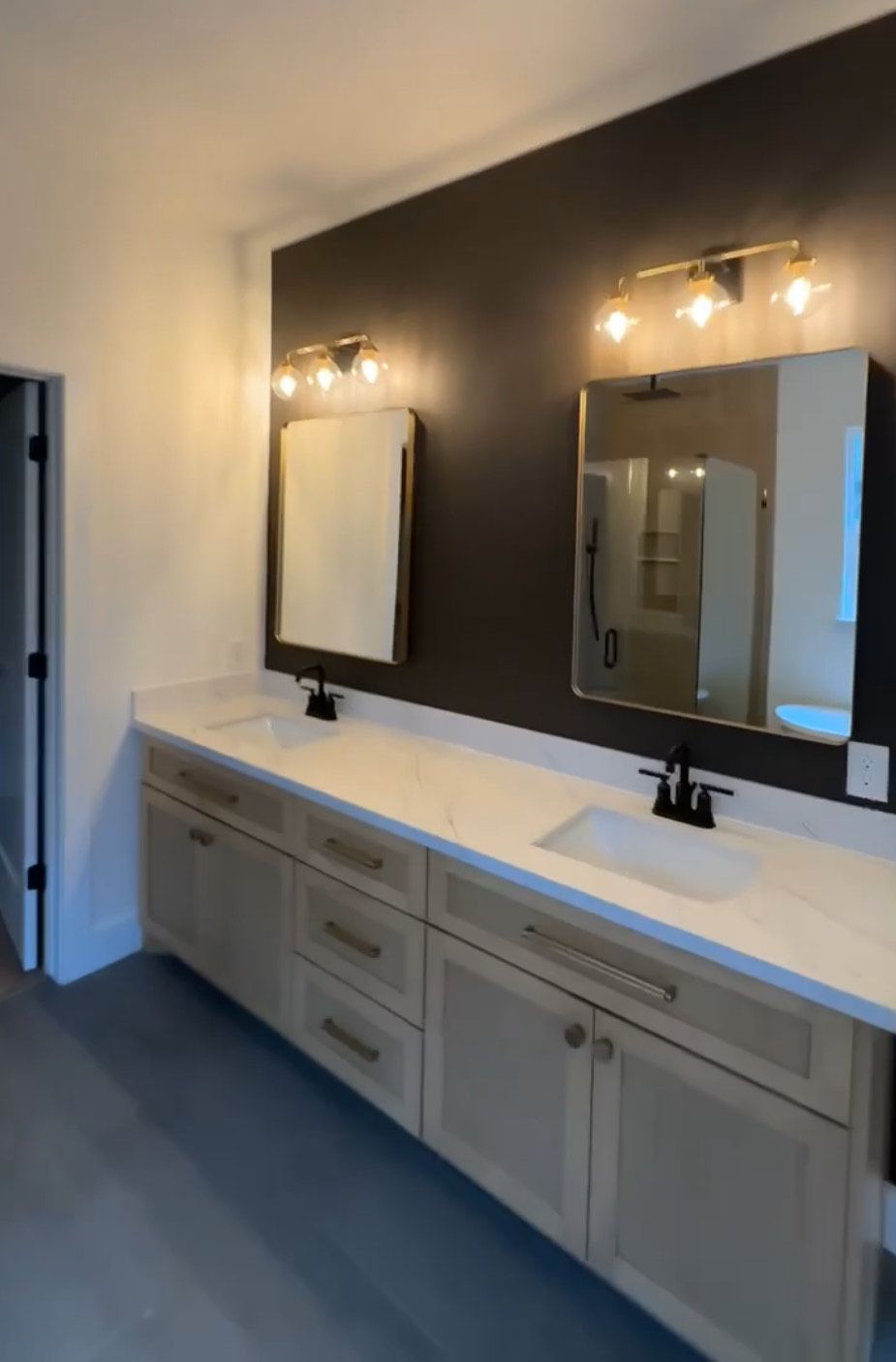 A modern bathroom with a double vanity. Light wood cabinets with a white countertop