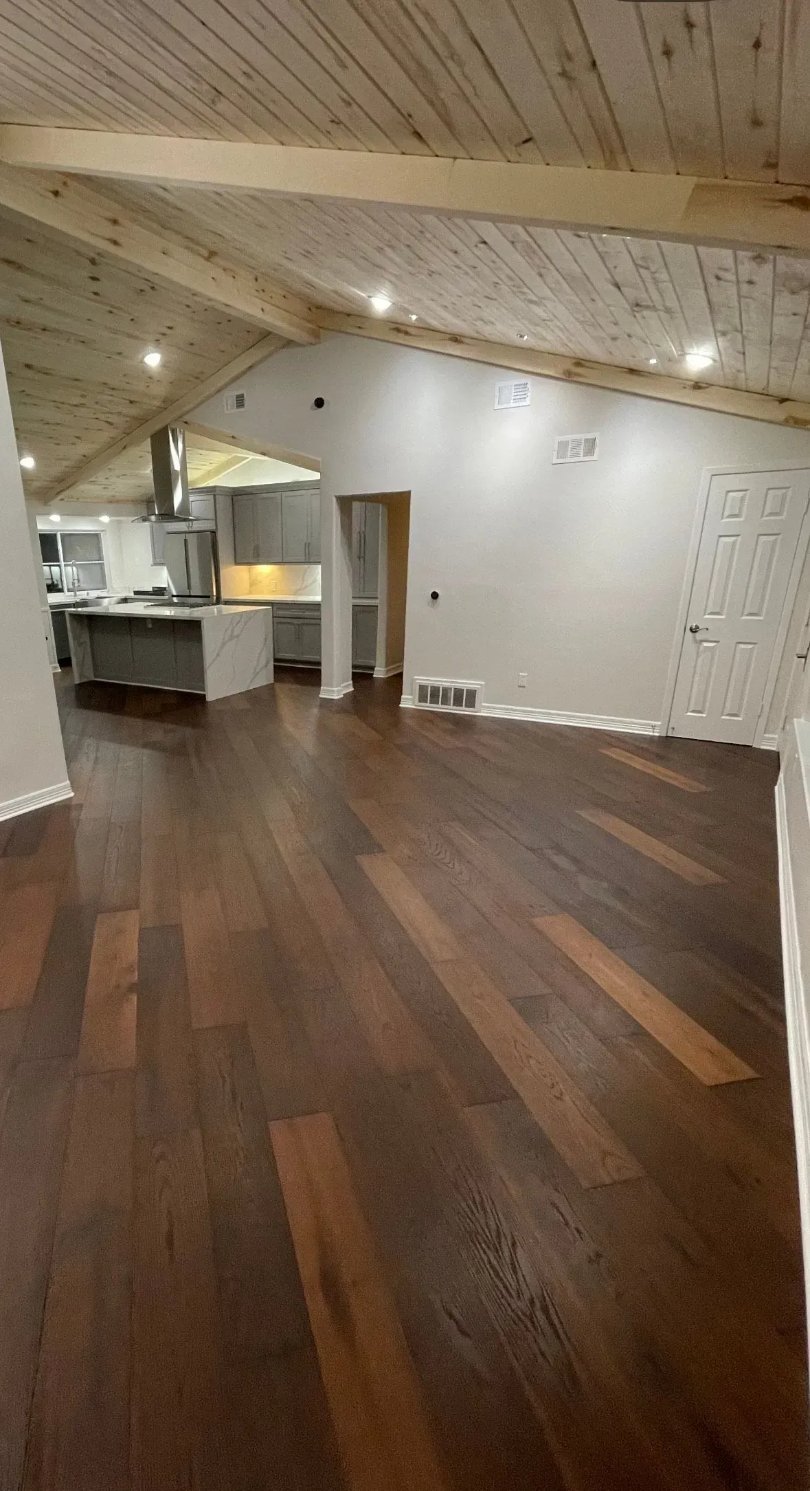 A kitchen with gray cabinets is visible in the background.