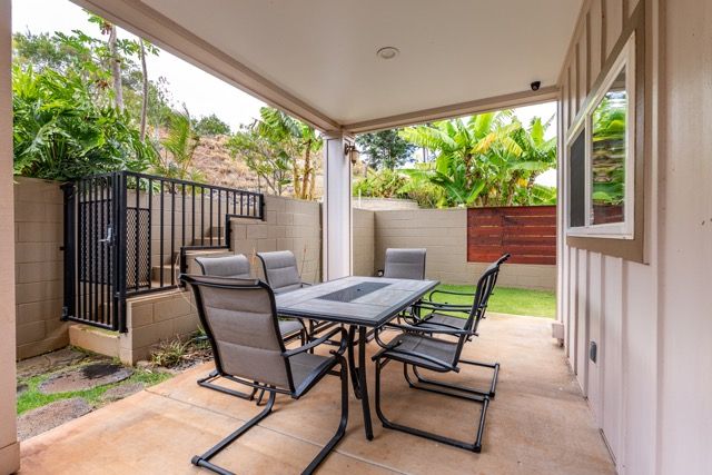 There is a table and chairs on the patio of a house.