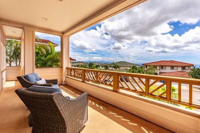 A balcony with wicker furniture and a view of the ocean